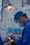 person in blue scrub suit holding clear glass cup